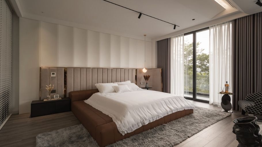 Phòng ngủ master với đầu giường da nâu, rèm trắng