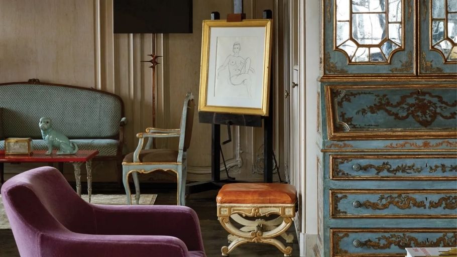 Góc trưng bày tinh tế với tủ cổ điển và giá vẽ nghệ thuật, thể hiện sự giao thoa văn hóa đặc trưng của tinh thần Chiết trung