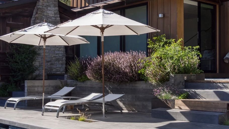 Góc hồ bơi biệt thự 2 tầng kiểu Pháp, ghế nằm và ô trắng bên tường gỗ sang trọng