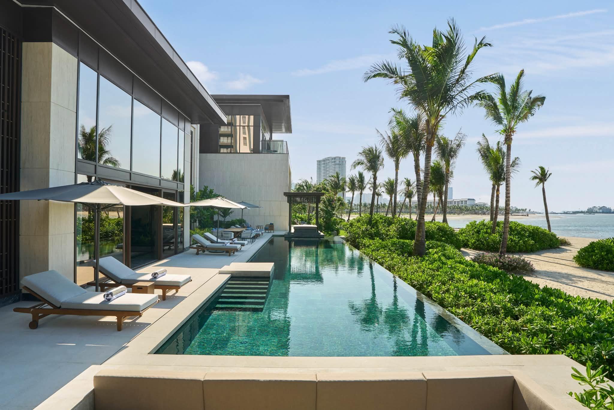 A luxurious beach villa design combining a private pool, green garden, and an ocean-facing view