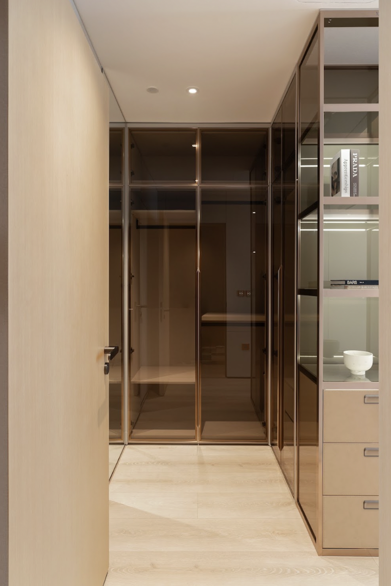 A private dressing room combining glass cabinetry and refined LED lighting, enhancing the user experience in the resting space.